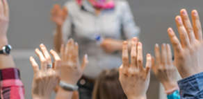 Photo of teacher and raised hands